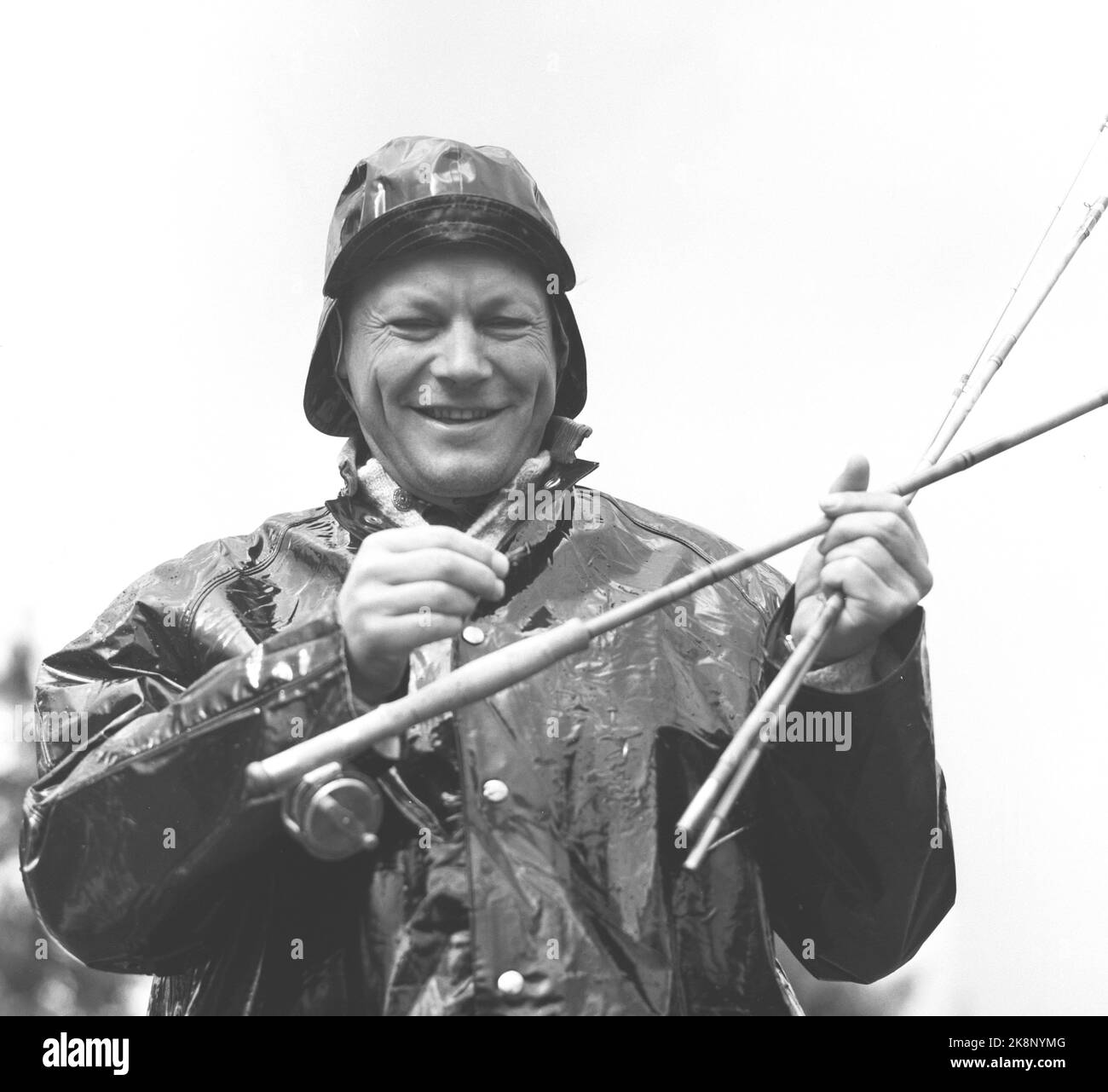 Sjusjøen 19580816. Hamarpiken Ruth und Willy Brandt Bürgermeister und Bundespräsident von Berlin (FH hier Willy Brandt, der sein Glück mit neuer Angelrute in Regen und Südwesten versuchen wird. Foto: Sverre Børretzen Current / NTB Stockfoto