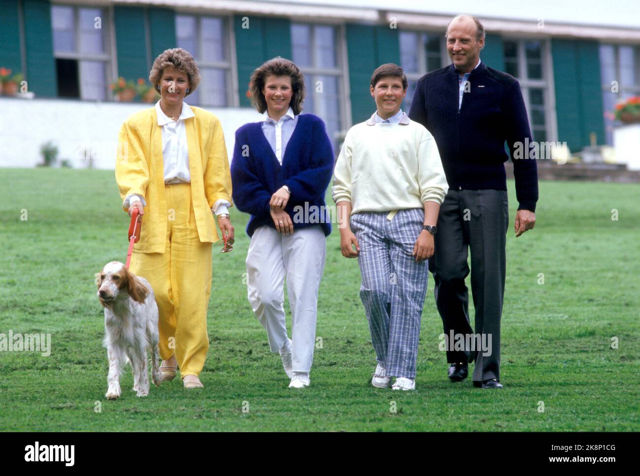 Skaugum 19870602 die Kronprinzenfamilie in Skaugum. Aus V: Kronprinzessin Sonja, Prinzessin Märtha Louise, Prinz Haakon Magnus und Kronprinz Harald mit dem Hund auf einem Spaziergang im Garten. Sonja im gelben Hosen Kostüm. Foto: Bjørn Sigurdsøn / NTB Stockfoto