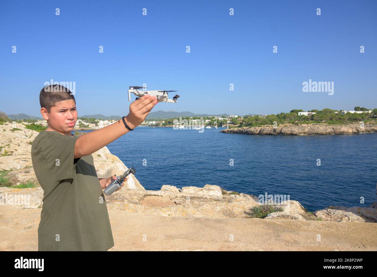 Glücklicher Teenager, der Flugdetails für Drohnenflug, Technologiekonzept Spanien, Balearen vorbereitet und abgeschlossen hat Stockfoto