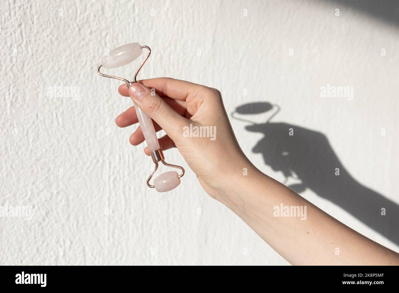 Gesichtswalze aus Steinjade und Massagegerät aus Gua Sha Rosenquarz. Gesichtspflege und Anti-Age-Produkte. Stockfoto