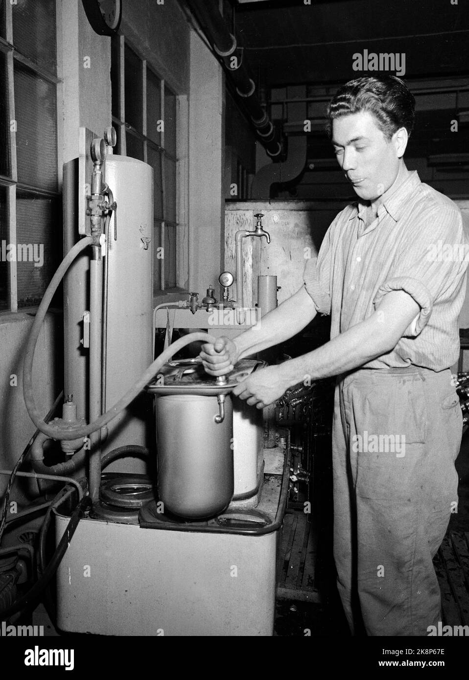 Oslo 19530314. Die Emameter in Hasle war die erste norwegische Fabrik nach dem Krieg, die mit der Herstellung der kleinen Waschmaschine „Evalet“ begann, die 1951 auf den Markt kam. Zum ersten Mal war es nicht möglich, die große Nachfrage von allen Seiten des Landes zu befriedigen. Das Unternehmen beschäftigt 200 Mitarbeiter und produziert Badewannen, emaillierte Waschbecken, Edelstahlwaschbecken und ca. 40.000 Waschmaschinen pro Jahr. Hier sehen wir, wie der dänische Leif Stick versucht, ob der Angestellte des Präsidenten richtig arbeitet. Foto: Sverre A. Børretzen / Aktuell / NTB Stockfoto