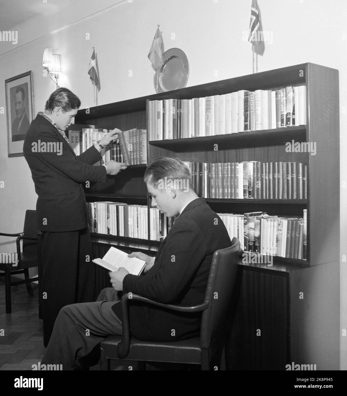 Antwerpen, 1956. Das Staatliche Wohlfahrtsamt für die Handelsflotte („Welfare“) hat 13 Night Out in wichtigen Hafenstädten auf der ganzen Welt eingerichtet. Hier aus Antwerpen, wo sie das Geschäft 1948 begannen. Das "Hotel Scandia" bildet die beiden obersten Etagen des neuen internationalen Seglerhauses, das 1954 eröffnet wurde. Hier ist der erste Jahrgang des Jungen Hummervoll (15 Jahre) aus Rennesøy (sitzend) und Reidulf Arntzen (17 Jahre) aus Lofoten, werfen Sie einen Blick auf die Bücher in der Bibliothek über 'Scandia'. Foto: Aage Storløkken / Aktuell / NTB Stockfoto