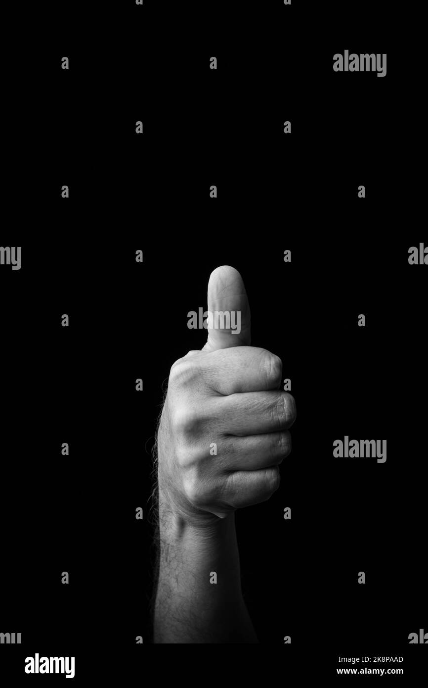 Dramatisches Schwarz-Weiß-Bild einer männlichen Hand, die den japanischen Zeichennachsbuchstaben 'TA' oder 'た' vor einem dunklen Hintergrund mit Kopierfläche schreibt Stockfoto