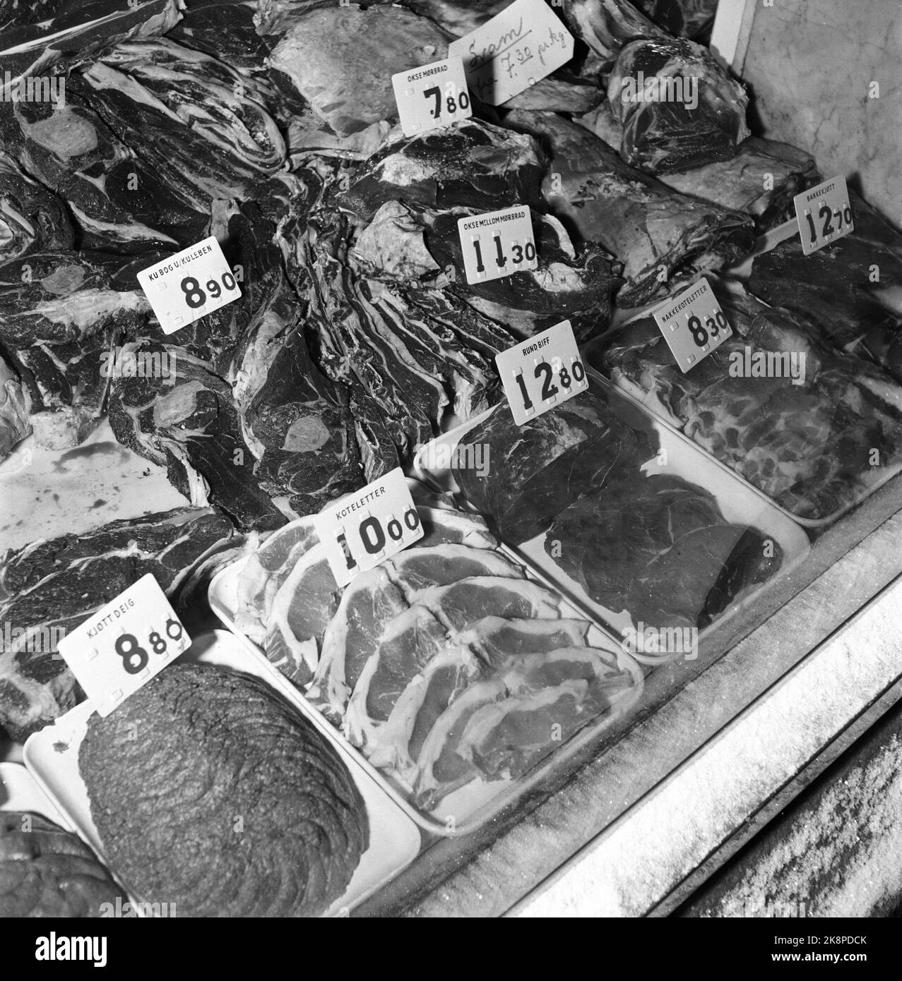Oslo Januar 1955: Der Verbraucherrat wurde 1953 mit dem Ziel gegründet, die Interessen der Verbraucher zu wahren, wie Preise, Produktion, Warenlieferungen, Handelsmarken, Verpackung und Standardisierung. Es war nicht offensichtlich, dass der Preis für die Fleischstücke per angegeben wurde. KILO, aber in diesem Laden wurden die neuen Plastikschilder mit austauschbaren Zahlen verwendet, was es leicht machte, die Ware korrekt zu berechnen. Foto: Aage Storløkken / Aktuell / NTB Stockfoto