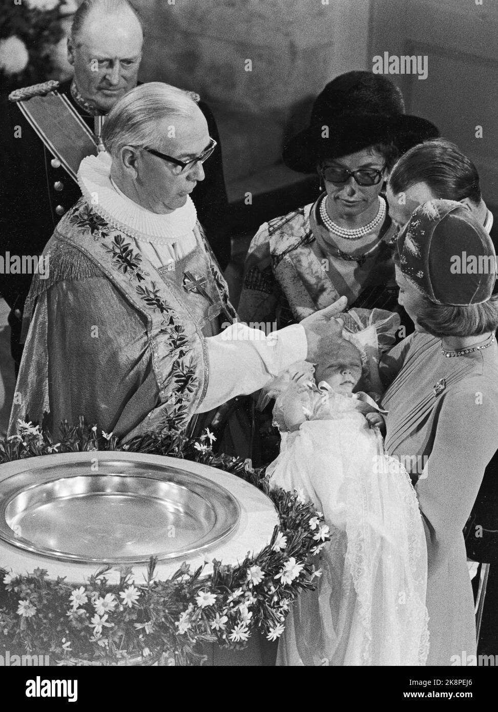 Oslo, das Schloss. 19730920. Prinz Haakon Magnus tauft auf dem Schloss. Kronprinzessin Sonja trägt ihren Sohn. Oslos Bischof Kaare Støylen führt das Taufritual durch - berührt die Stirn des Taufkindes mit Wasser aus dem Taufbecken. Im Hintergrund König Olav und Prinzessin Aestr Mrs. Ferner. Foto: NTB-Archiv / NTB Stockfoto