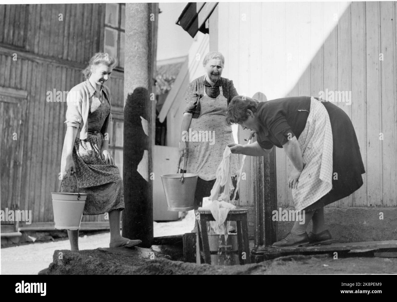 Oslo 19561001 die Altstadt von Enerhaugen, die Ende 50s / Anfang 60s abgerissen wurde. Hier Frauen / Hausfrauen, die an der Wasserpfosten Kleidung waschen. Foto: NTB / NTB Stockfoto