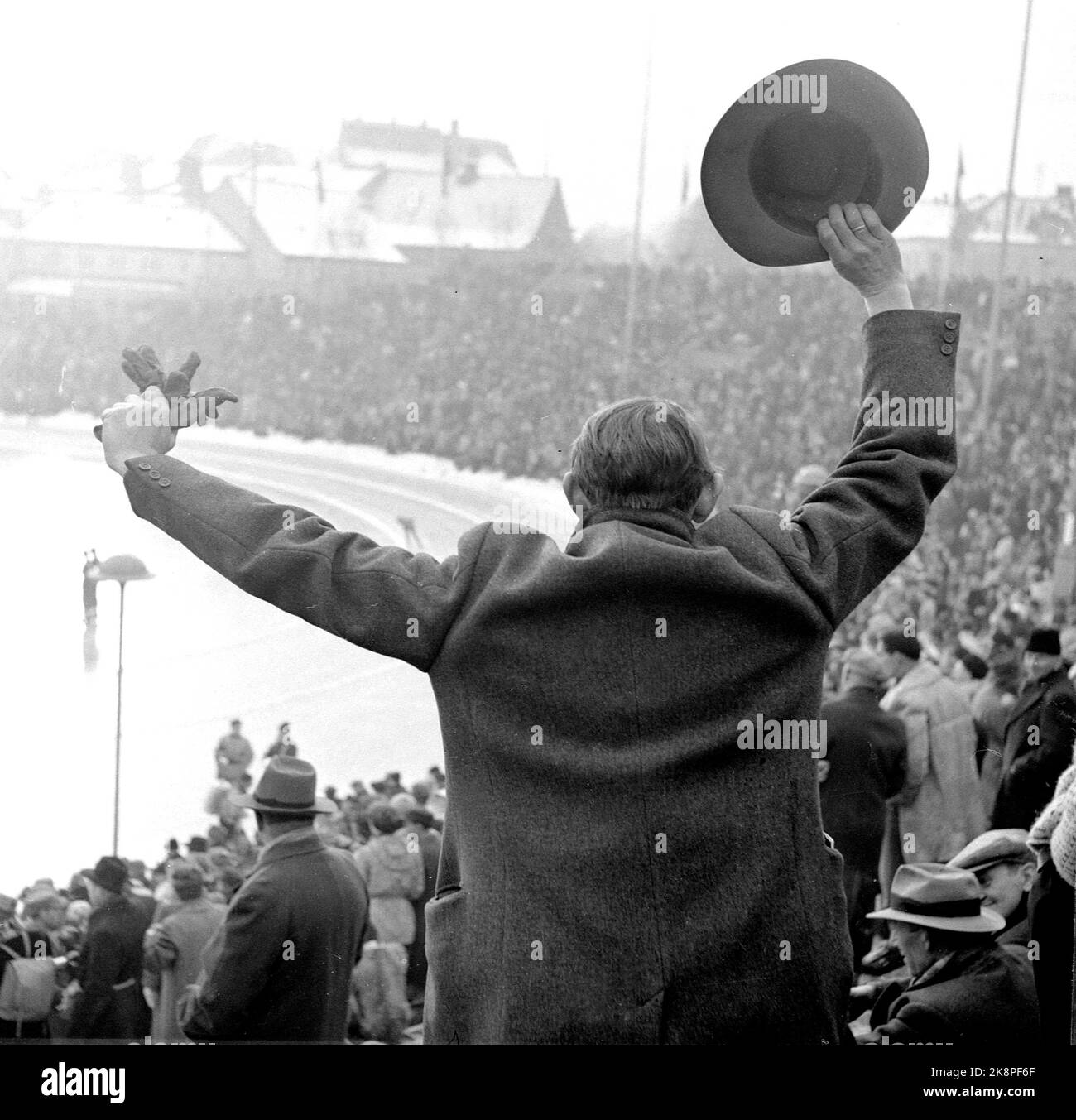 19520219 Oslo: Olympische Spiele, Winterolympiade, Schlittschuhlauf, schnelles Rennen, 10.000 Meter: Große Menschenmassen folgten den Rennen im Bislett Stadium. Tolle Atmosphäre, als Hjalmar Andersen auf 10.000 Metern Gold gewann. Mann mit Hut und Mantel steht auf und jubelt. Foto: Current / NTB Stockfoto