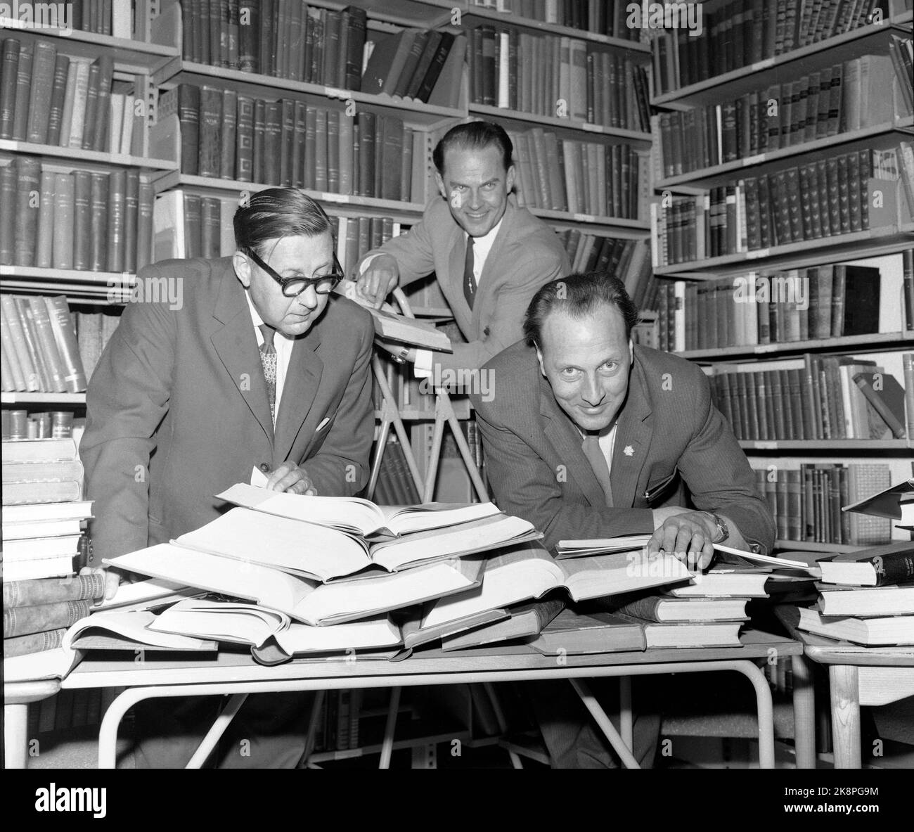Oslo 19610503 NRK Television bereitet die Quizzes "Get Rid of or Double" vor, bei denen die Spitzenprämie bis zu 10.000 NOK beträgt. Hier ist eine Gruppe von NRK-Leuten dabei, Fragen für die ersten Kandidaten zu stellen. Von V: Leiter der Bibliothek des NRK Jon Lid (mit Brille), Programmsekretär Erik Diesen mit Buch in der Hand) und Programmredakteur Otto Nes (über den Tisch). NTB/NTB Stockfoto Oslo 19610503 NRK Television bereitet die Quizzes "Get Rid of or Double" vor, bei denen die Spitzenprämie bis zu 10.000 NOK beträgt. Hier ist eine Gruppe von NRK-Leuten dabei, Fragen für die ersten Kandidaten zu stellen. Von V: Leiter der Bibliothek des NRK Jon Lid (mit Brille), Programmsekretär Erik Diesen mit Buch in der Hand) und Programmredakteur Otto Nes (über den Tisch). NTB/NTB Stockfoto