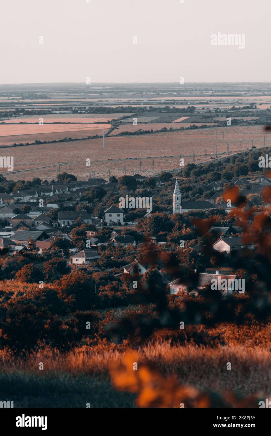 Eine Vertikale einer schönen ländlichen Stadt in der Nähe von goldenen Feldern bei Tageslicht Stockfoto