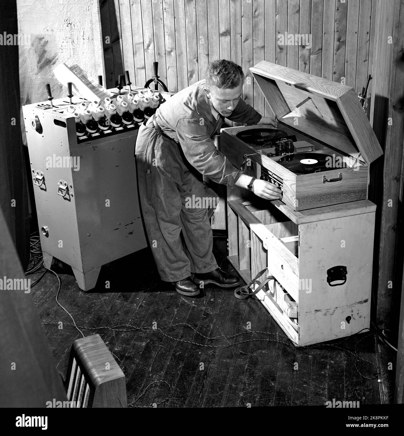 Bø in Telemark Oktober 1950. Das Nationaltheater auf Tour. Hier ist der heutige Auftritt im Bauernhaus Hus Fagerheim in Bø vorbereitet. Der Schauspieler Odd Borgen, der jüngste des Nationaltheaters, hat einen harten Job. Er ist sowohl Schauspieler als auch Lichtmeister und ist auch für das Grammophon mit den Soundeffekten verantwortlich. Hier das Schloss am Grammophon. Foto: Current / NTB Stockfoto