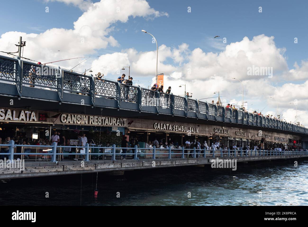 Blick auf die Fischer auf der Galata-Brücke und Fischrestaurants in Istanbul. Das Bild spiegelt den Lebensstil und die Kultur der Menschen vor Ort wider Es ist ein sonniger Sommertag Stockfoto