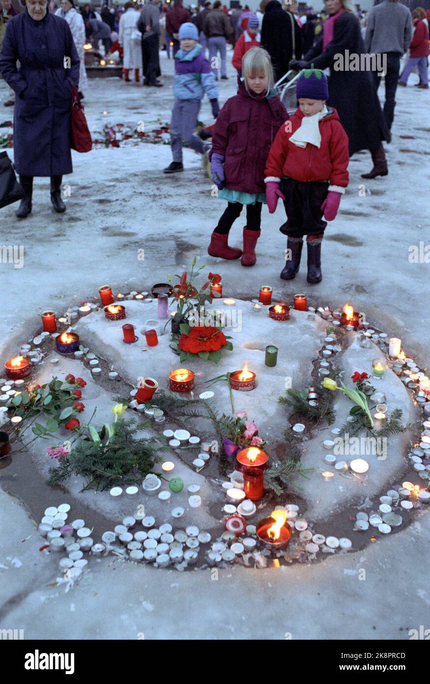 Oslo 19910120: König Olav V. ist tot. Am Schlossplatz versammeln sich die Menschen. Mournal zündet Kerzen an, schreibt Grüße und legt Blumen auf den Schlossplatz. Das Bild: Anton, 5 Jahre, mit Freundin Julie Elena, bewundert das blumenorientierte Monogramm des verstorbenen Königs, das im Schnee bei Slottsplassen angefertigt wurde. 24803/18 Foto: Annica Thomsson / NTB / NTB Stockfoto