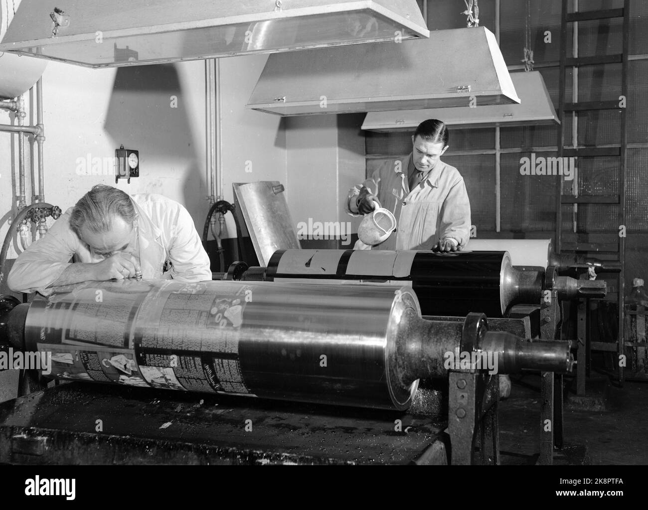 Oslo 1950 das Wochenmagazin 'Current' ist fünf Jahre alt, die erste Ausgabe datiert vom 16. Juni 1945. Hier aus dem Bericht „Ein modernes Wochenmagazin verwandelt sich in“ Letzter Prozess vor dem Druck. Die Pigmentmembran wird in den Zylinder geätzt, indem Säure darüber gegossen wird. Die Seiten - im Spiegelbild - werden mit einer Lupe untersucht. Foto: Current / NTB *** das Foto wurde nicht verarbeitet ***** Stockfoto