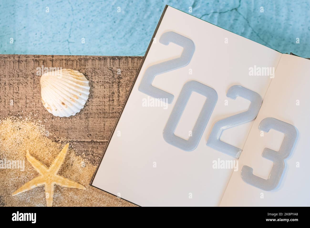 Frohes neues Jahr 2023 Konzept mit einer Schale und einem Seestern am Pool. Winterurlaub in der Sonne. Stockfoto