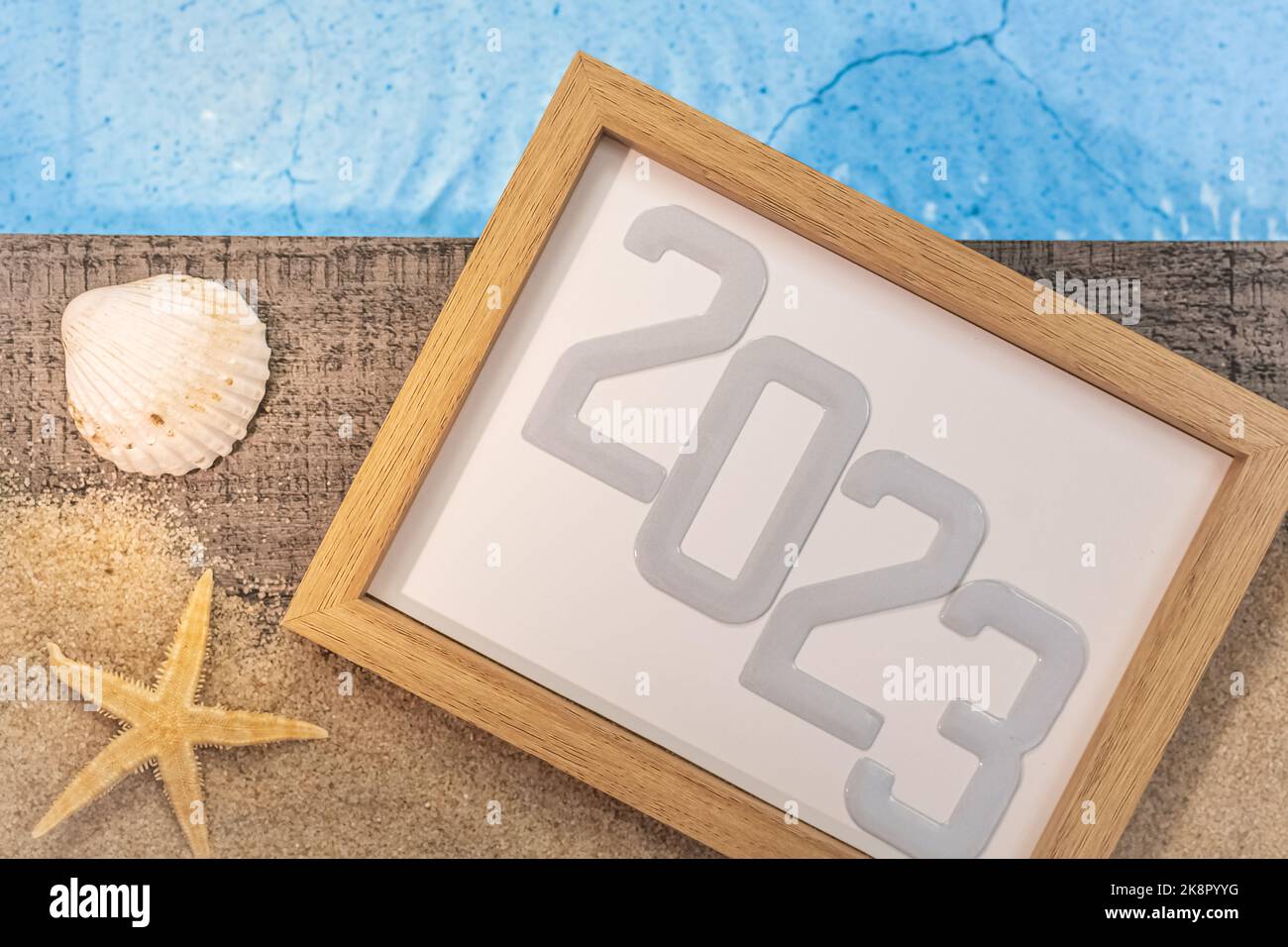 Frohes neues Jahr 2023 Konzept mit einer Schale und einem Seestern am Pool. Winterurlaub in der Sonne. Stockfoto