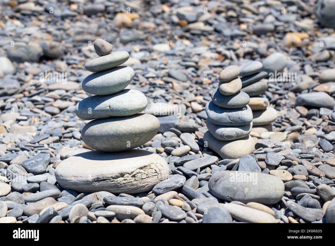 Kieselsteine an der Küste sind in einer Pyramide gestapelt. Ruhe und Entspannung, ein Gefühl der Ausgewogenheit. Stockfoto
