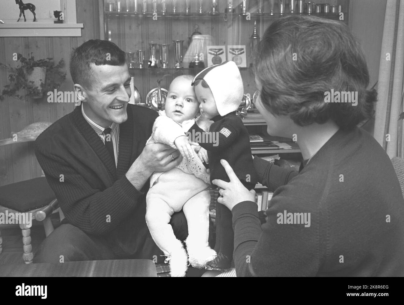 Nøtterøy 19641205. Skater Fred Anton Maier (26 Jahre) fotografiert in seinem Haus mit Frau Kari und Sohn Svend Anton Koser mit als Skater gekleideter Puppe Maier stellt die Tønsberg-Kurve dar, ist 1,92 m hoch und ist unsere größte Skating-Hoffnung, nachdem sich das 'Coupé' gestellt hat. Foto: Ivar Aaserud NTB / Current Stockfoto