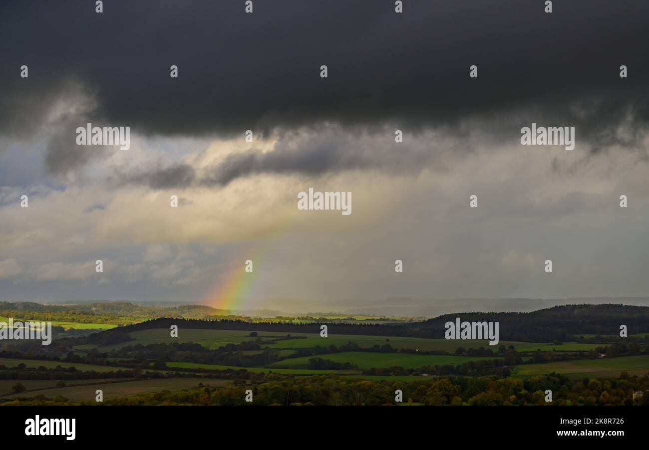 Win Green, Wiltshire, Großbritannien, 24.. Oktober 2022, Wetter: Ein Regenbogen bildet sich aus dunklen Wolken und einem heftigen Regenschauer, der die Grenzlandschaft von Wiltshire Dorset aus der Sicht von Win Green, dem höchsten Punkt auf Cranborne Chase, durchquert. Paul Biggins/Alamy Live News Stockfoto