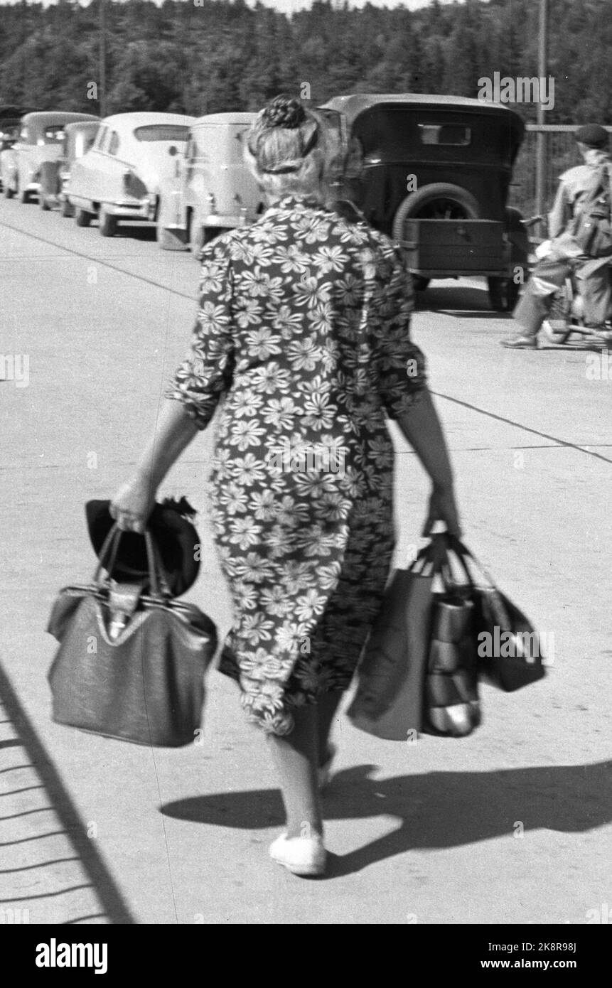 Svinesund 1952; Zuckerfieber! Norweger haben den Bach nie für Wasser überquert, aber oft über den Kiel für andere Waren. In der Nachkriegszeit war Zucker ein lang erwartetes gut, da es bis 1952 Rationierungen gab. Als es erlaubt wurde, 10 Kilo Zucker pro Reisenden zu importieren, explodierte der Grenzhandel. Norwegische Autofahrer füllten das Auto mit '' Zuckerkids '', die ihr Gewicht wert waren, wenn nicht Gold, also zumindest in Zucker! Diese Hausfrau trägt die Taschen voll und typisch floral Kleid. Foto; Sverre A. Børretzen / Aktuell / NTB Stockfoto