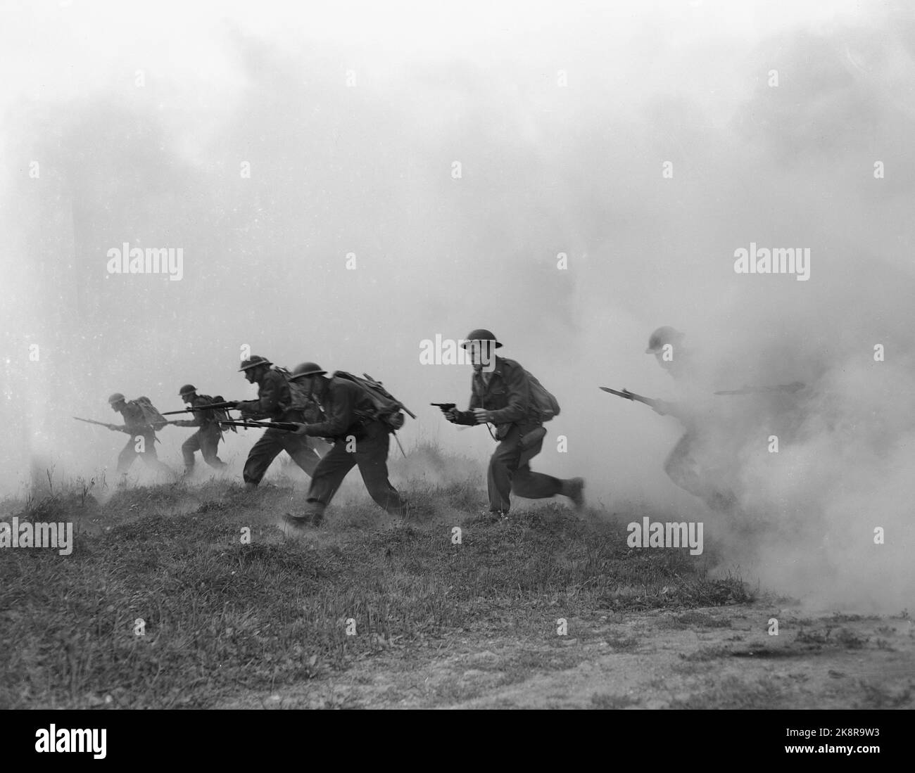 Norwegen 19500916 "Norwegen bereitet sich auf den bewaffneten Frieden vor" die Fotos wurden vom derzeitigen Mitarbeiter Sverre A. Børretzen gemacht, der in den sehr realistischen Übungen und Manövern, die die Armee, die Marine und die Luftwaffe in letzter Zeit gehalten haben, enthalten ist. Die Regierung und andere zuständige Behörden stellen die Frage der verstärkten Bereitschaft zur Sprache. Von der Übung mit der Armee. Soldaten laufen mit Waffen in der Hand. Foto; Sverre A. Børretzen / Aktuell / NTB Stockfoto