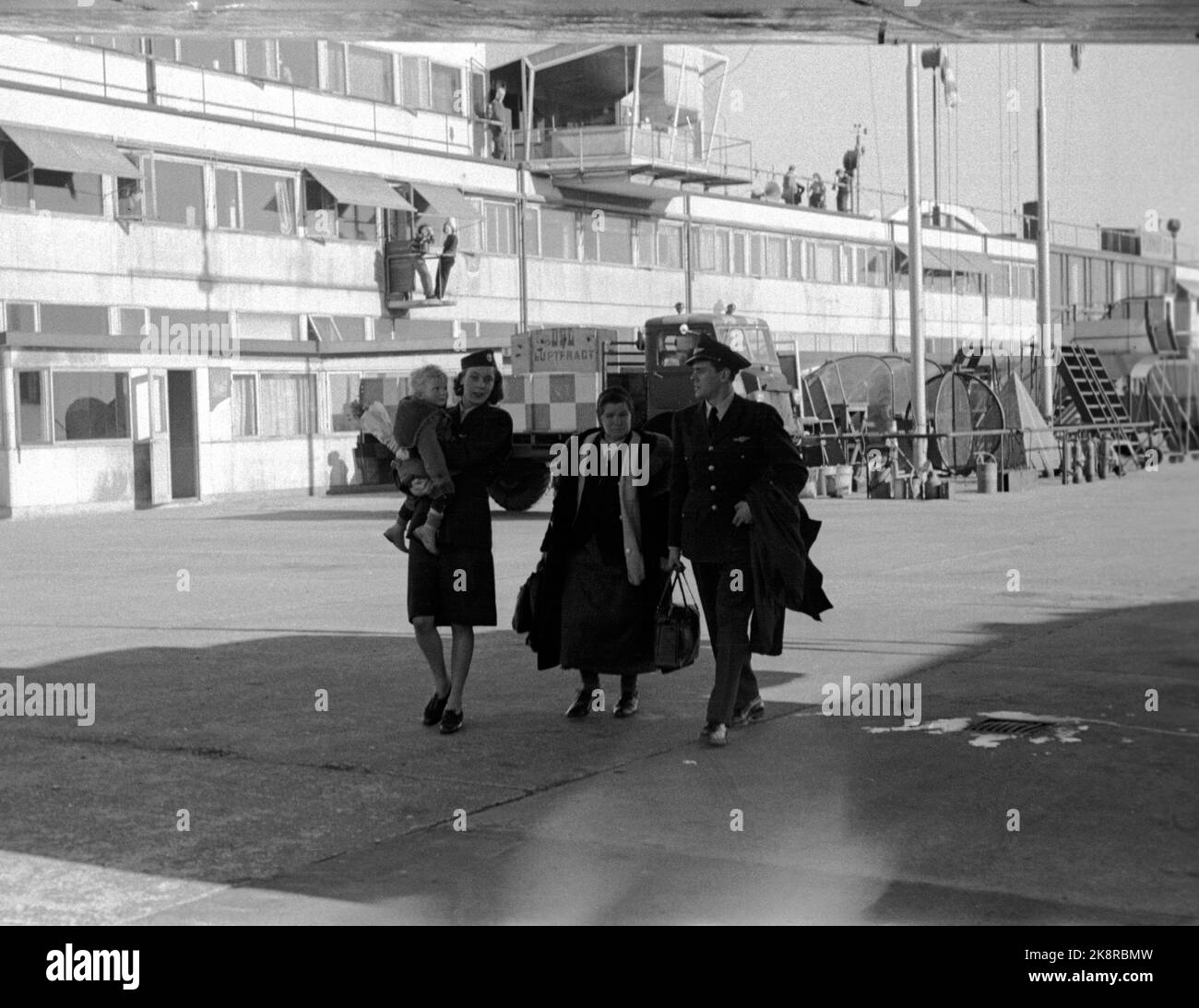 Kopenhagen, Dänemark, 1948 SAS FLYRUTE KOPENHAGEN / NEW YORK. Die Besatzung des Flugzeugs hilft Frauen mit kleinen Kindern. Der Flugbegleiter trägt das Kind auf seinem Arm. Foto: Current / NTB Stockfoto