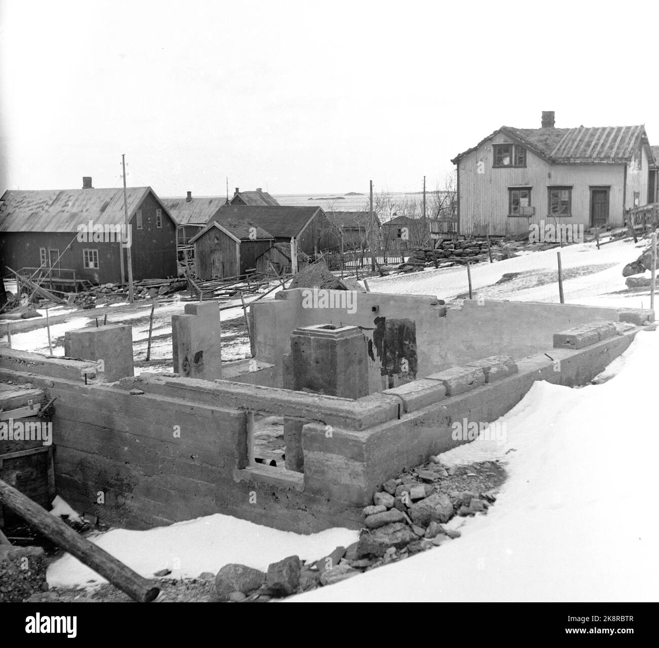 Lofoten, Winter 1951. Mehrere Fischerdörfer in Lofoten werden geräumt, weil sie ohne Strom, Straßen-, Kais- und Telefonanschluss nicht betrieben werden können. An einigen Orten haben die Gemeinden beantragt, Geld vom Staat zu bewegen, um die Häuser und die gesamte Bevölkerung zu bewegen, wie hier in Refsvik außerhalb von Lofotodden. Hier befinden sich meist nur die Grundmauern, während die Häuser nach Sørvågen verlegt wurden. Foto: Sverre A. Børretzen / Aktuell / NTB Stockfoto