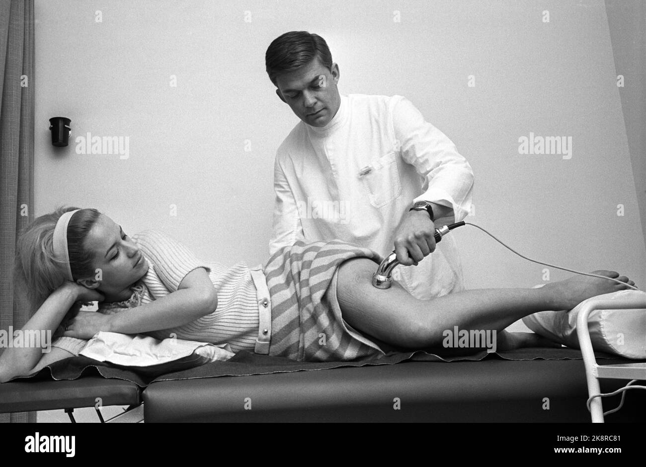 Oslo 18. März 1967. Die schwedische Künstlerin Lill-Babs wird von der Norwegerin und dem Nationalmannschaftswärter Kjell Kaspersen wegen einer Verletzung behandelt, die sie erlitten hat, als sie während eines Tests auf Chat-Noir von der Bühne fiel. Die beiden sind zukünftige Ehepartner, aber das Bild wurde aufgenommen, bevor sie Freunde wurden. Hier behandelt Physiotherapeut Kaspersen die Oberschenkelverletzung von Lill-Babs galvanisch, d.h. dass er mit einem speziellen Kraftgerät - und Ultraschall das gerinnte Blut abspaltet. Foto: Ivar Aaserud / NTB / NTB Stockfoto