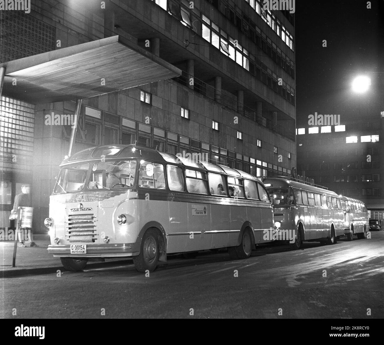 Arvika, Schweden 195412. Norwegische Hausfrauen haben Arvika erobert. Im Dezember wurde die Stadt von bis zu 20 norwegischen Bussen überfallen, die von Hausfrauen zum Weihnachtseinkauf verpackt waren. Lange Schlangen von Hausfrauen im Kolonialladen und im Spielzeugladen, um billig einzukaufen, was sie zu Weihnachten brauchen. An manchen Tagen gibt es bis zu 6-700 weihnachtliche Einkaufsfrauen. Hier sehen wir die Busse in einer Reihe, die norwegische Hausfrauen nach Arvika bringen. Foto: Aage Storløkken / Aktuell / NTB Stockfoto