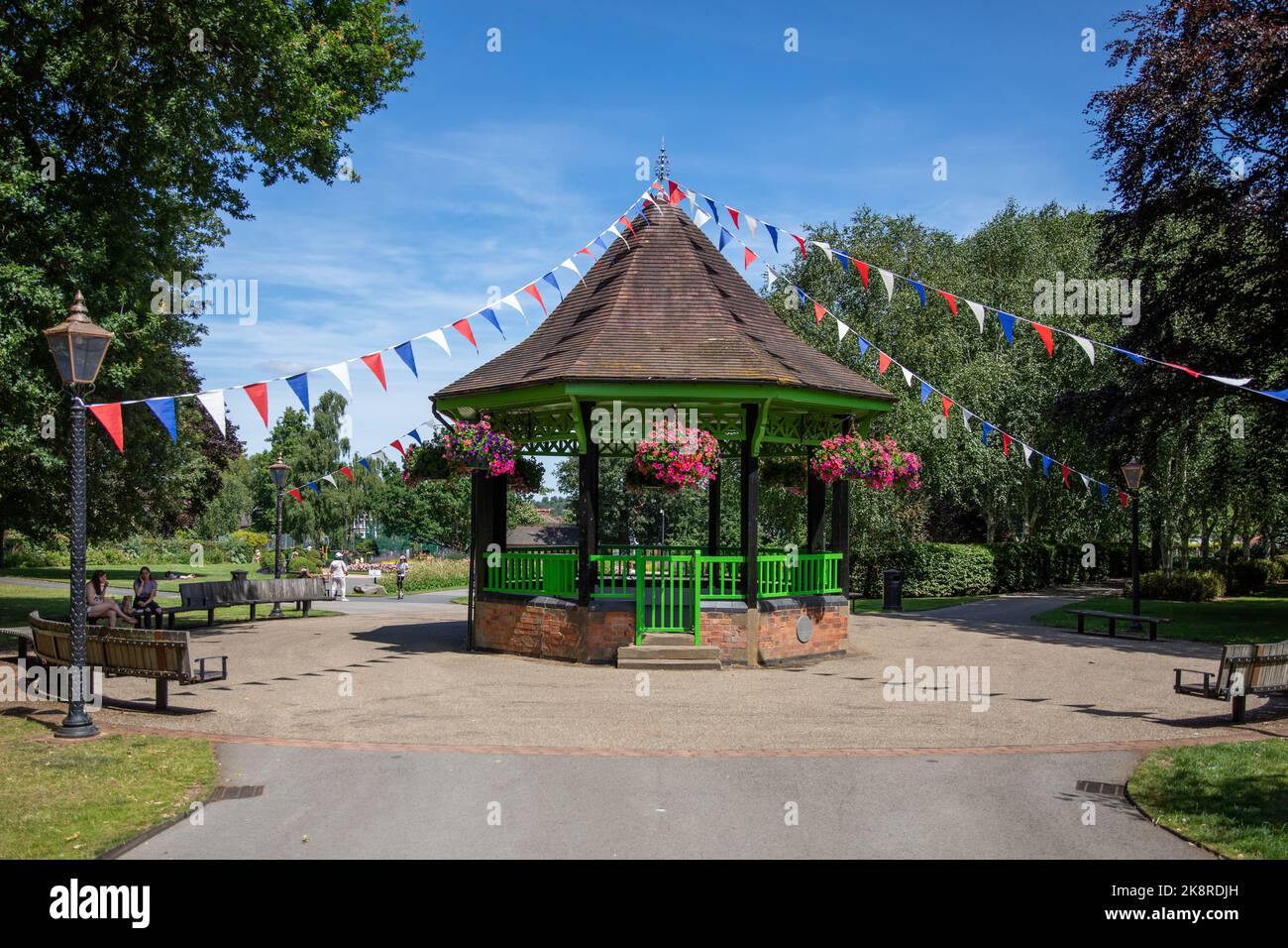 Ein Bandstand über Festivalflaggen im Herbert Park unter einem sonnigen Himmel im Garten Stockfoto