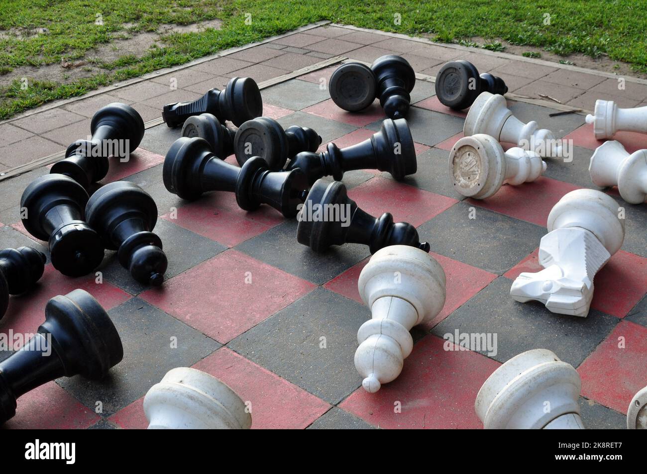 Schachfiguren, die auf einem Mega-Schachset umgestoßen wurden. Stockfoto