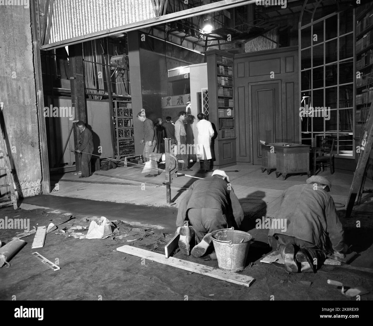 Oslo 1952-10: Nach mehr als 30 Jahren Arbeit und großen Geldmitteln, einschließlich des Kinoüberschusses in Oslo, eröffnet Folketeatret nächsten Monat im Youngstorget in Oslo. Hier sind Bilder von den letzten Vorbereitungen vor den Eröffnungspräparaten. Gleichzeitig mit den Schauspielern, die Tests auf der Bühne haben, sind die Arbeiter beschäftigt die Bauarbeiten. Das Bild: Die Szene ist voller Dekorationen - an Tante Ulrikke - während die Handwerker im Vordergrund stehen. Foto: Sverre A. Børretzen / Aktuell / NTB Stockfoto