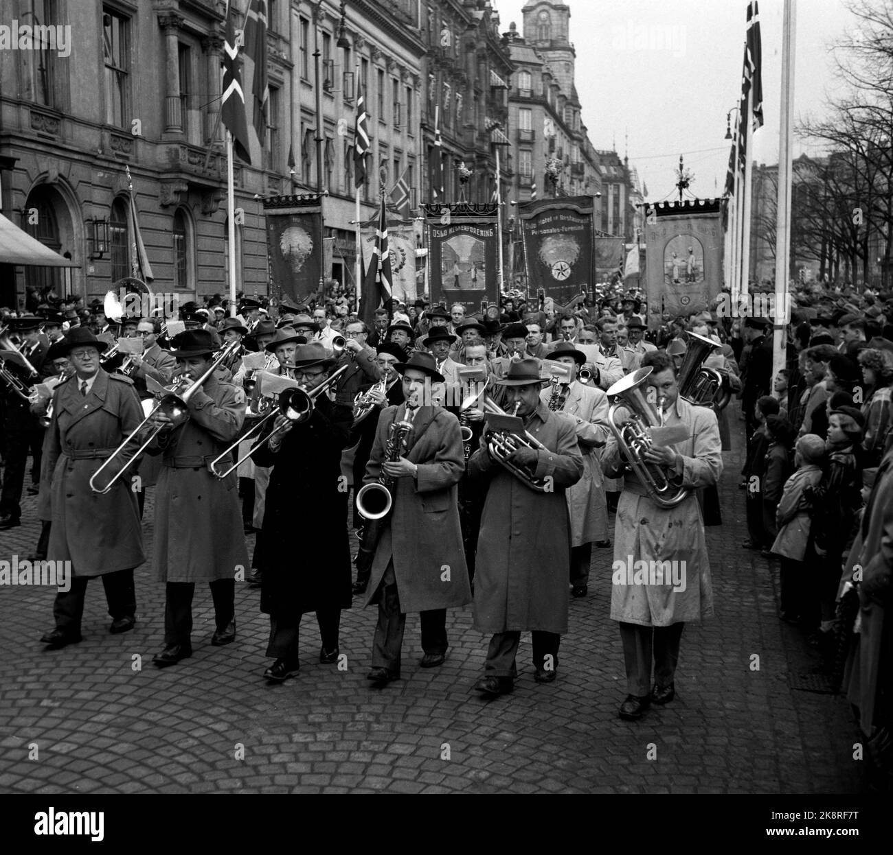 Oslo 19540501. Mai 1 Zug entlang Karl Johans Tor. Tabs und Banner, Zuschauer folgen dem Zug und Männer spielen, Posaune, Saxophon und Althorn. Foto: NTB / NTB Stockfoto