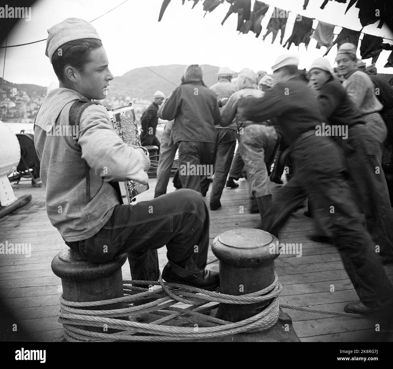 195207. Bergens Schulschiff 'Statsraad Lehmkuhl' die 1700 Tonnen Segelschiff segelt auf See über den Atlantik gegen New York mit 180 ersten Reisegiffen an Bord. Das Segelschiff liegt seit 1948 am Byfjord in Bergen abgeschieden. Es ist das erste Mal, dass ein norwegisches Schulschiff mit nur erstmaligen Jungen auf lange Geschwindigkeit einschiffte. Tolle Aktivitäten auf der Terrasse, die Wäsche hängt zum Trocknen, Junge spielt Akkordeon für die Arbeit. Stock Photo: Sverre A. Børretzen / Aktuell / NTB Stockfoto