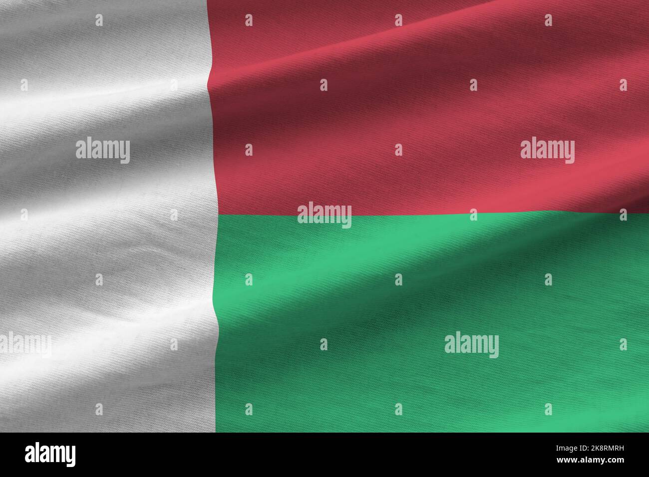 Madagaskar-Flagge mit großen Falten winken aus nächster Nähe unter dem Studiolicht im Innenbereich. Die offiziellen Symbole und Farben in Stoff Banner Stockfoto