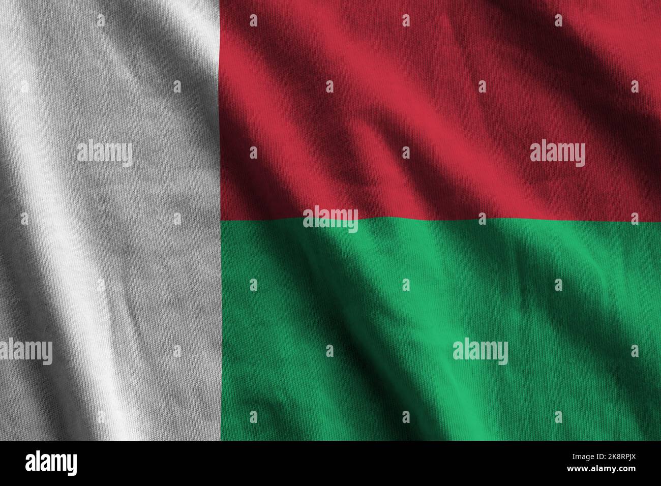 Madagaskar-Flagge mit großen Falten winken aus nächster Nähe unter dem Studiolicht im Innenbereich. Die offiziellen Symbole und Farben in Stoff Banner Stockfoto