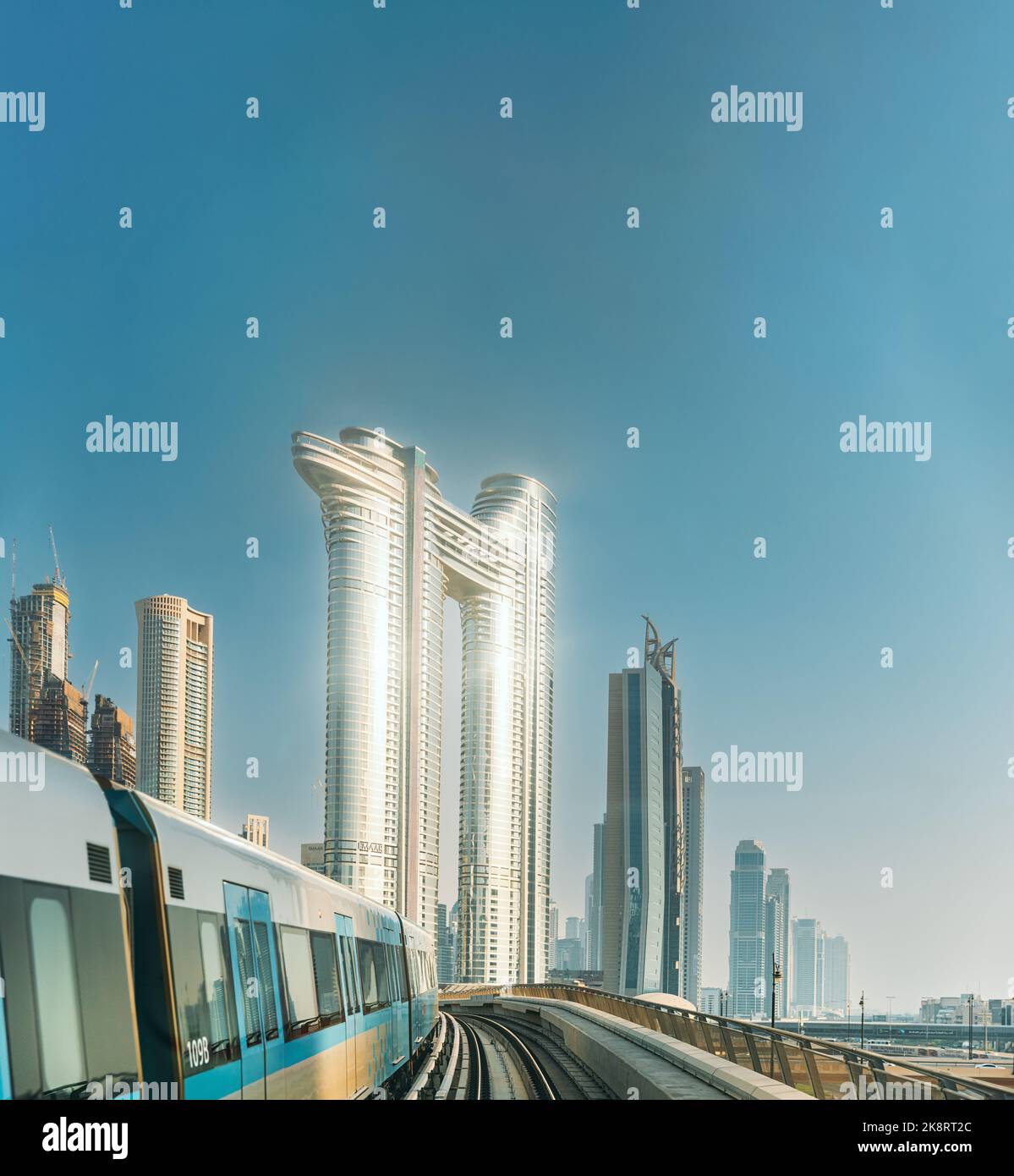 Monorail Subway fährt zwischen gläsernen Wolkenkratzern in Dubai. Verkehr auf der Straße in Dubai. Skyline mit Stadtbild. Städtischer Hintergrund Stockfoto