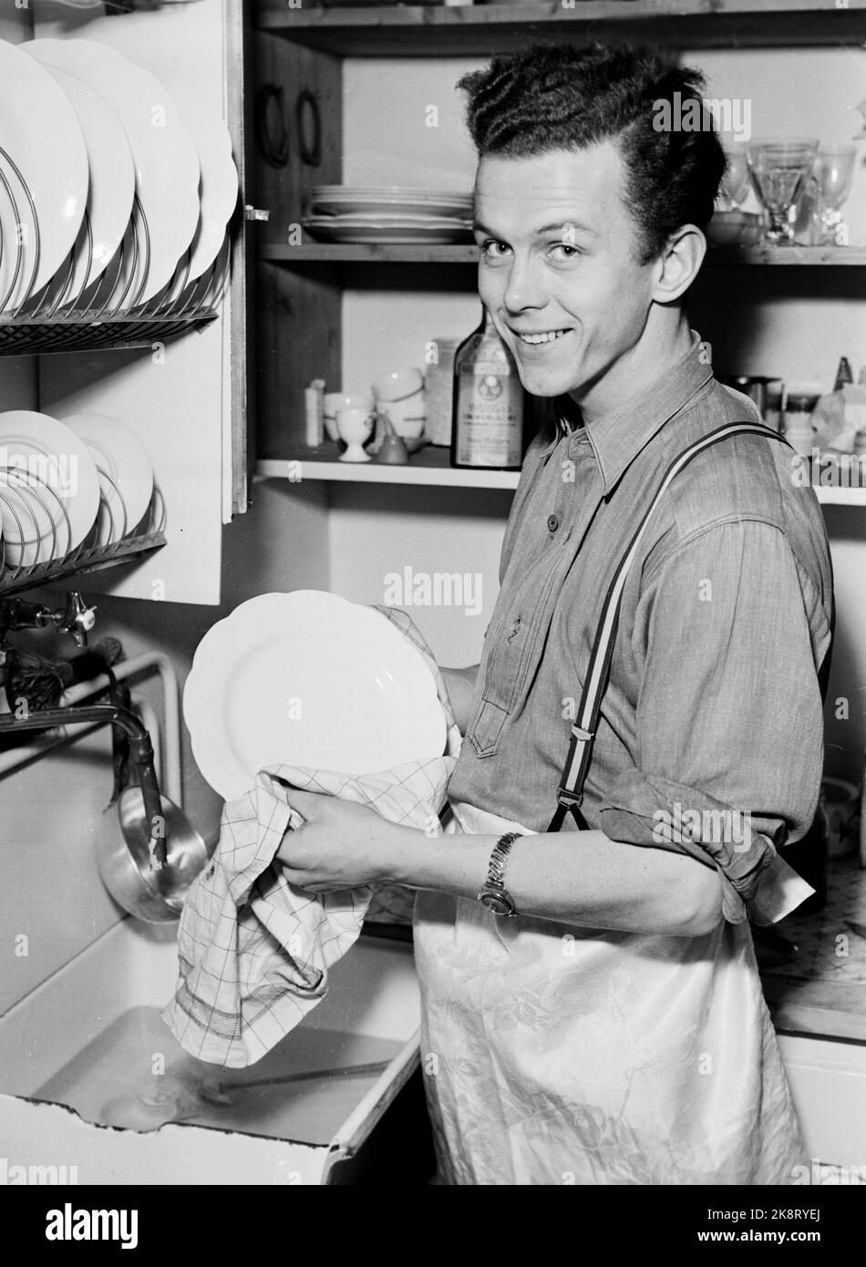Oslo 19501205. Schauspieler Toralv Maurstad wäscht sich zu Hause in der Küche aus. Lächelt. Hausarbeit. Foto: NTB / NTB Stockfoto