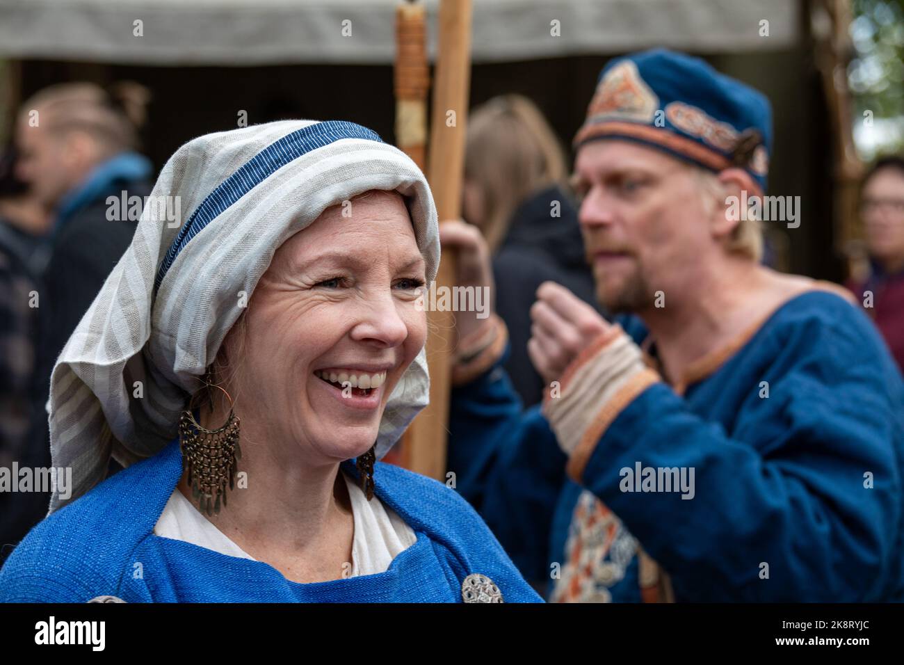 Lachende weibliche Reenakteurin beim Pukkisaari-Markt aus der Eisenzeit im Stadtteil Vähä-Meilahti in Helsinki, Finnland Stockfoto