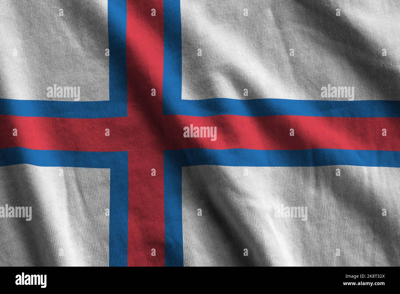 Die Flagge der FäröerInseln mit großen Falten, die in Innenräumen