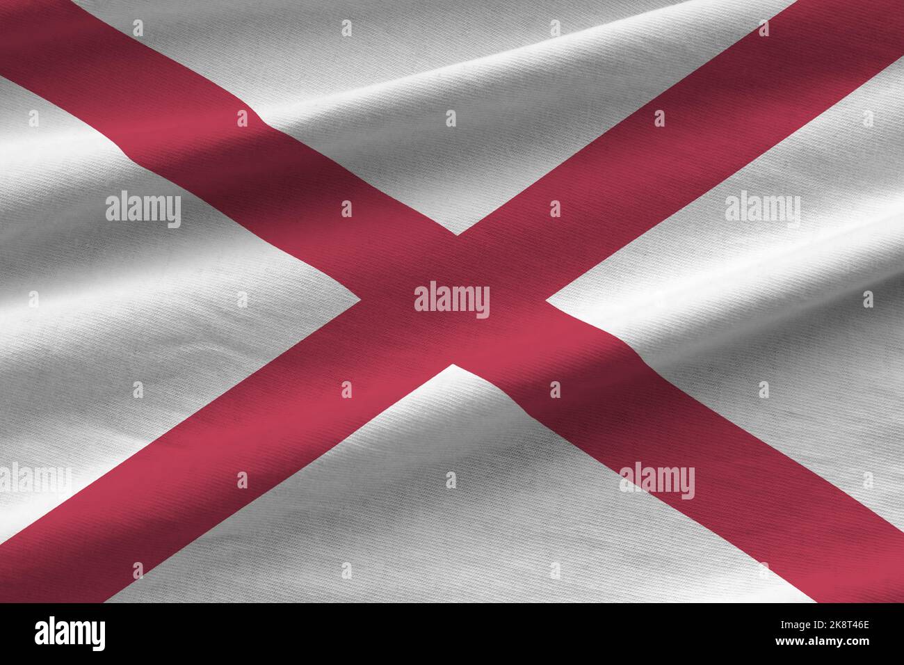 US-Staatsflagge von Alabama mit großen Falten, die in Innenräumen unter dem Studiolicht winken. Die offiziellen Symbole und Farben in Stoff Banner Stockfoto