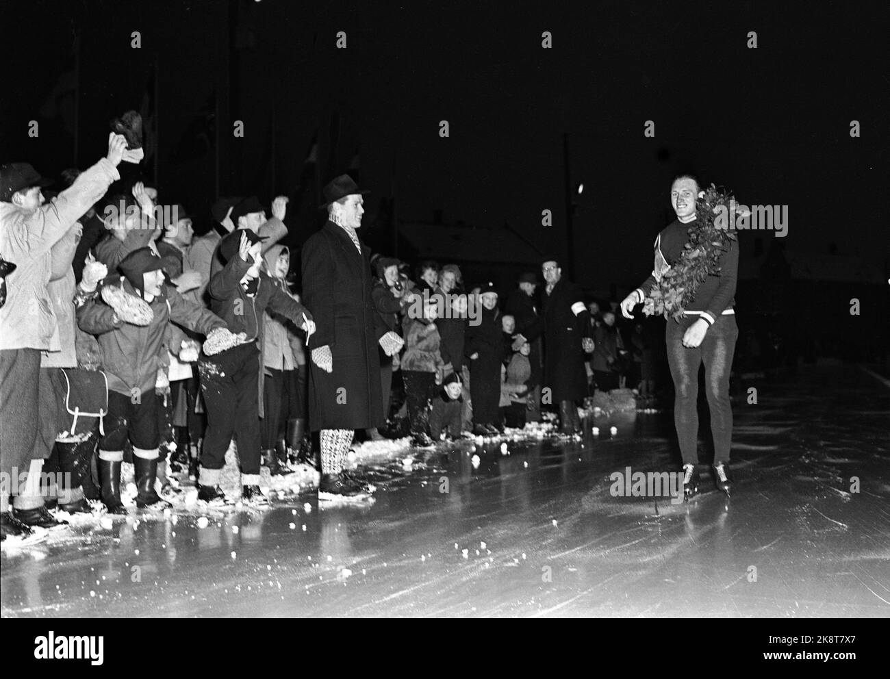 Hamar 19530201 Europameisterschaft / Europameisterschaft beim Skaten / Schnelllauf im Hamar-Stadion. Der Europameister Kees Broekman (Niederlande) wird im Dunkeln des Abends im Hamar-Stadion von einem großen Publikum gepriesen. Broekman in voller Figur mit Lorbeerkranz. Foto: NTB / NTB Stockfoto