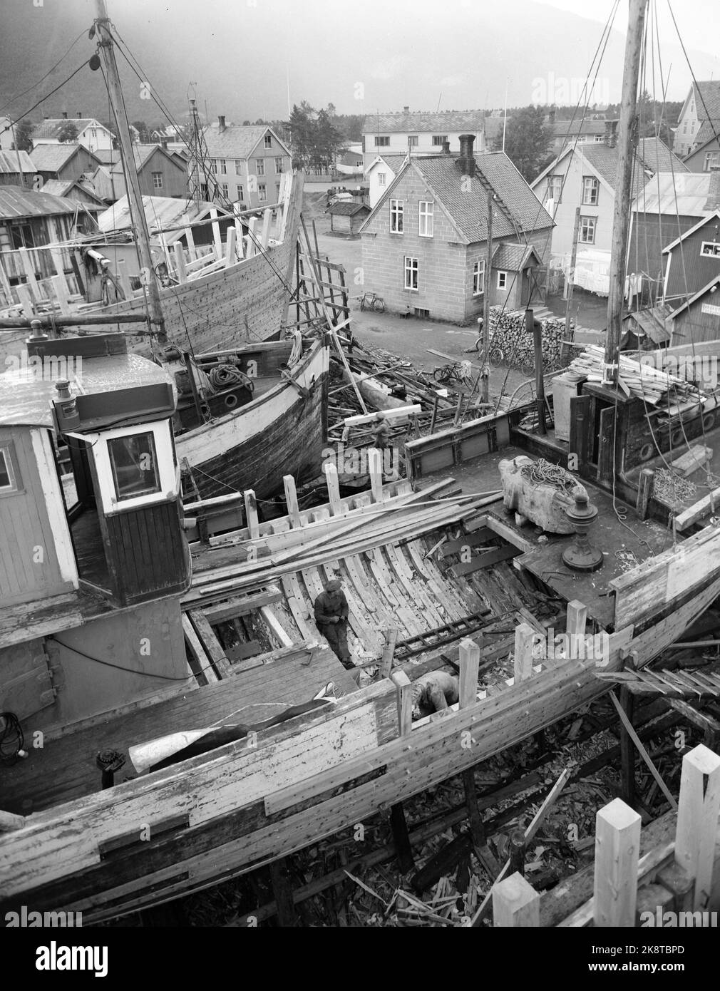 Rognan innerst i Saltdalsfjorden 19531010. Rognan er kjent over hele Nord-Norge som stedet hvor fiskeskøyter bygges Og repareres. Småskipsbyggingen har urgamle tradisjoner, for hundrevis AV år siden sto Folk Og bygde båter i små skur nede i Fjæra. De fleste bøndene har en båt for seg selv på låven i vedskjulet eller i et skur. Båtene bygges i mørke Høst--Og vinterdagene når arbeidet med gardsbruket ikke stjeler så mange timer AV døgnet. Langs hele stranda i Rognan er skøyter under bygging eller til reparasjon. Foto: Sverre A. Børretzen / Aktuell / NTB Stockfoto