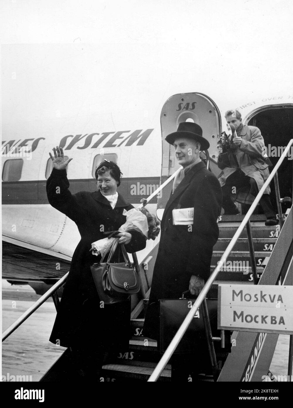 Oslo 1955. Werna Gerhardsen und Einar Gerhardsen auf ihrem Weg nach Moskau an der Spitze einer norwegischen Delegation, um die Möglichkeiten für ein erweitertes Handelsabkommen zu diskutieren. Oben auf der Treppe: Der aktuelle Fotograf Sverre A. Børretzen. Sie winken. Foto: Aage Storløkken / Current / NTB Strive light 46/55 Stockfoto