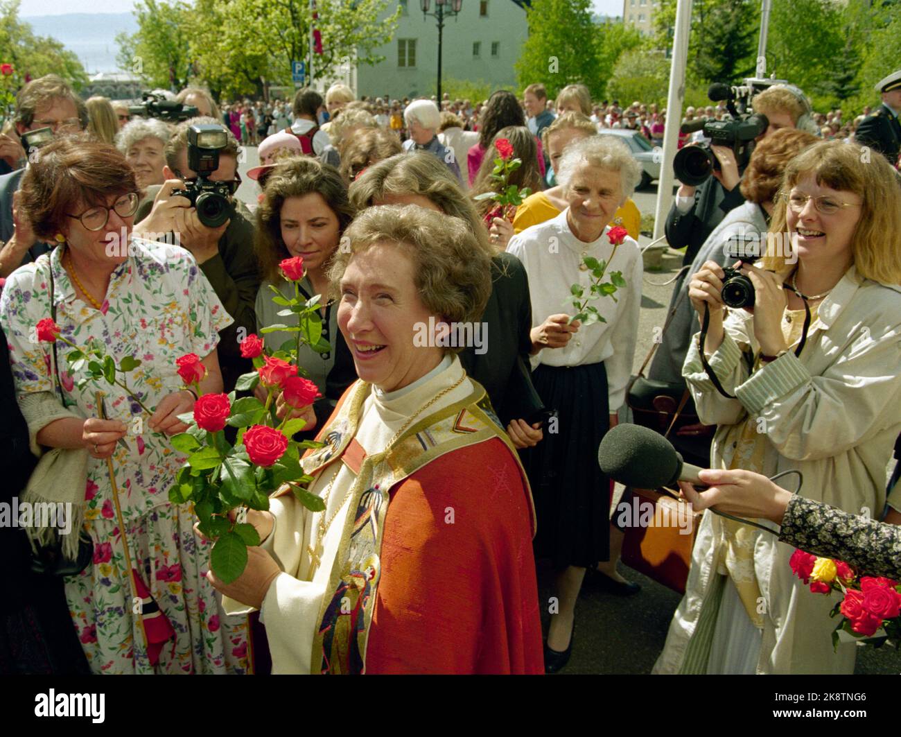 Hamar 19930520: Diözese Norwegens erste Bischofin. Hamars neue Bischof Rosemarie Köhn wird im Hamardom geweiht. Hier lächelt Köhn mit roten Rosen und vielen Gratulanten vor dem Dom nach der Hochzeit. Foto: Bjørn Sigurdsøn / NTB / NTB Stockfoto