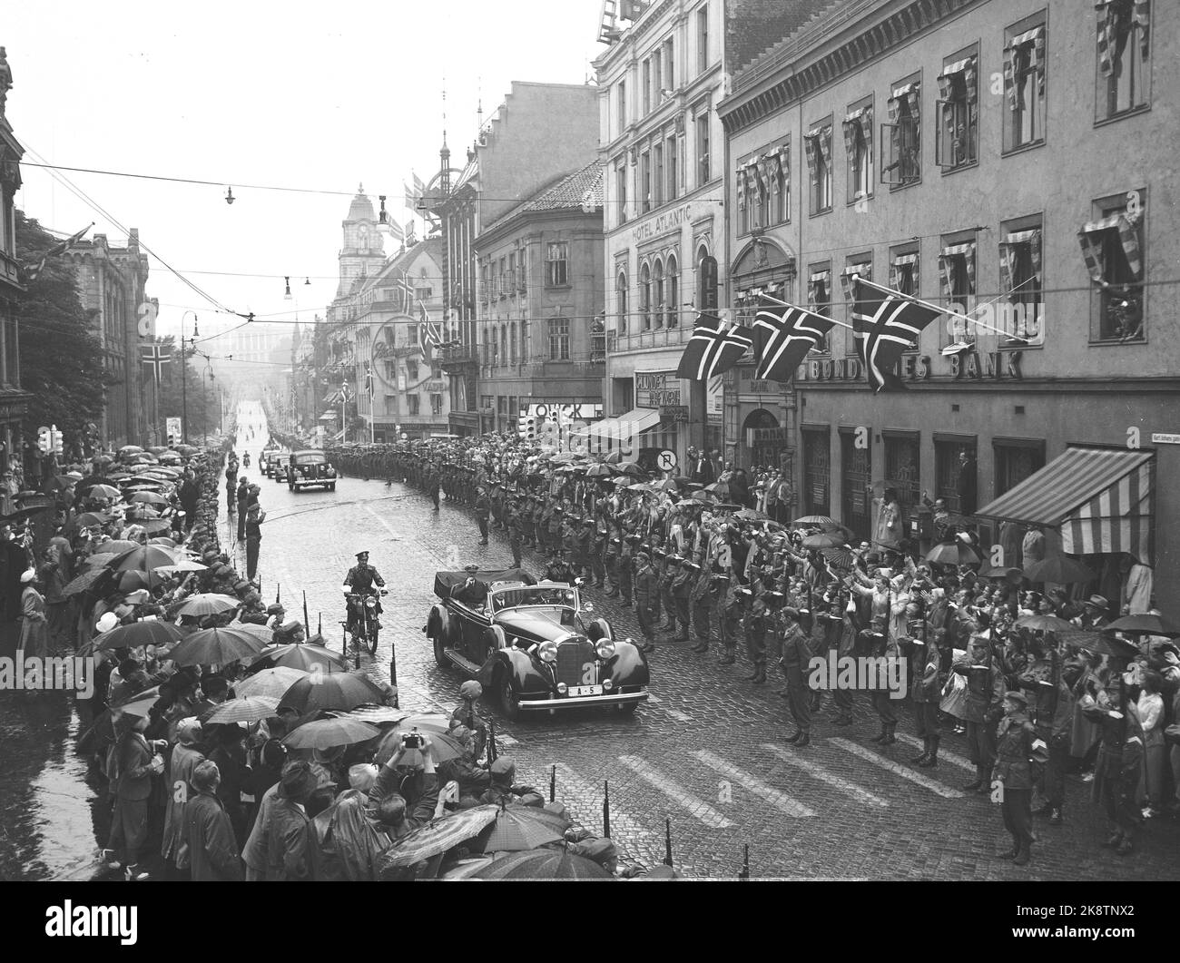Oslo 19520803. König Haakon 80 Jahre 3. August 1952. König Haakon fuhr bei Regenwetter mit dem Auto A 5 durch Oslo. Hier vom Karl Johans Tor. Viele Menschen waren im Regen anwesend, um einen Blick auf den König zu erhaschen. FOTO: VALLDAL NTB / NTB Stockfoto