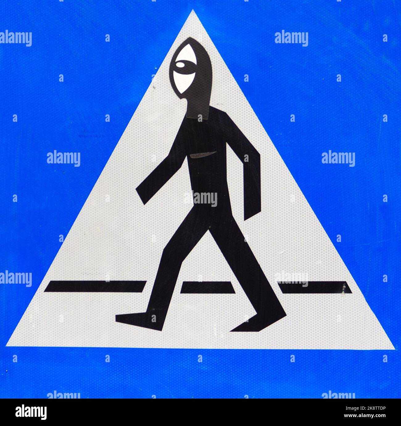 Verändertes Fußgängerüberweg-Zeichen, urbanes Kollage-Kunstwerk, Poznań, Polen, humorvolle Intervention an Verkehrssymbolen Stockfoto