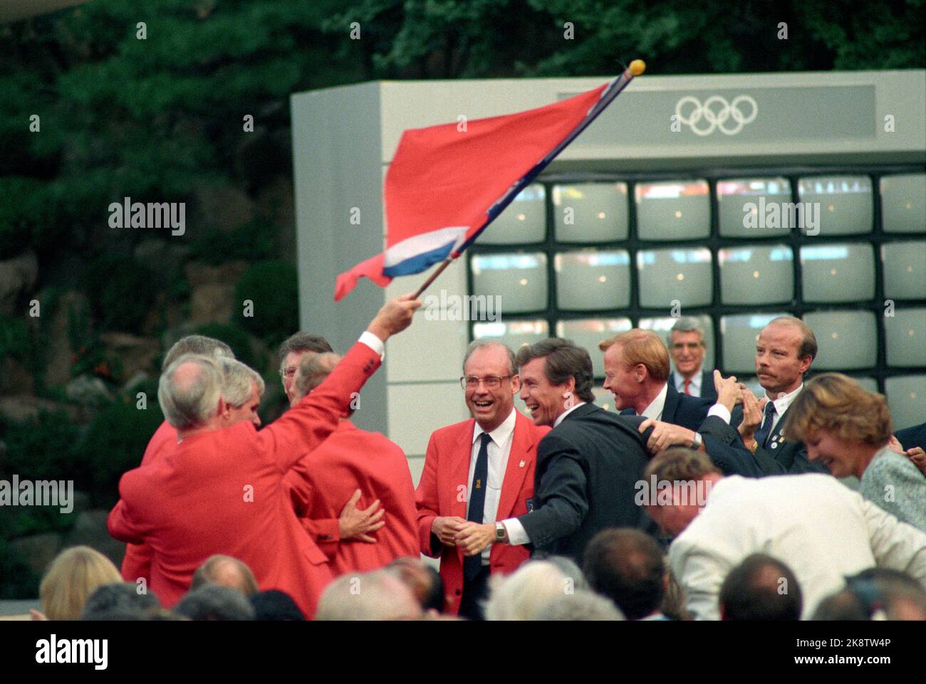 Seoul 1988-09-15:-und der Gewinner ist Lillehammer! Olympische Winterspiele 1994, Lillehammer, Norwegen. Die in Seoul anwesende norwegische olympische Delegation jubelt. Auf dem Bild mit Ole Scetne, Hallvard Bakke und Hans B. Skaset. Tore Strand mit der norwegischen Flagge. Foto: Inge Gjellesvik Stockfoto