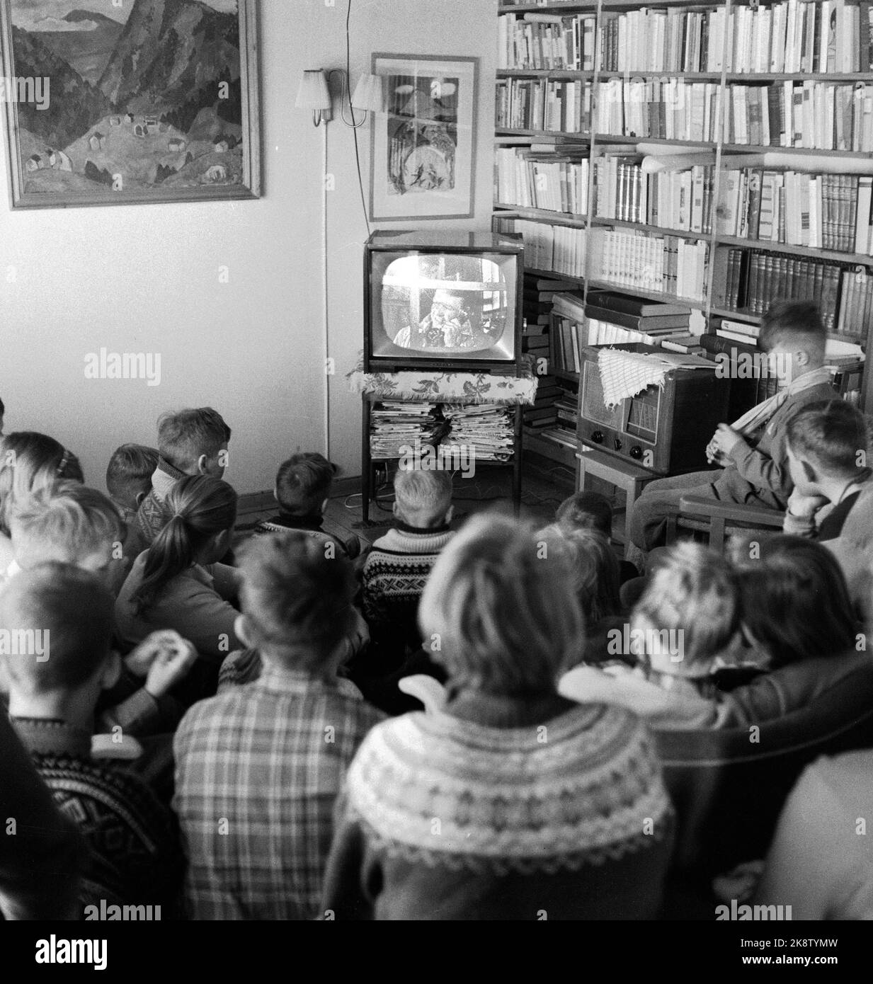 Oslo 19580413 die erste Woche regelmäßiger Testübertragungen im Fernsehen von NRK nimmt an, und das Interesse unter den wenigen, die einen Fernsehapparat haben - und all ihren Freunden - ist riesig! Hier Interieurs aus einem Wohnzimmer, wo die Möbel jetzt in den Halbkreis um den Fernseher gruppiert. Das Wohnzimmer ist voll von Kindern und Erwachsenen. Foto: Pipeline / Aktuell / NTB Stockfoto