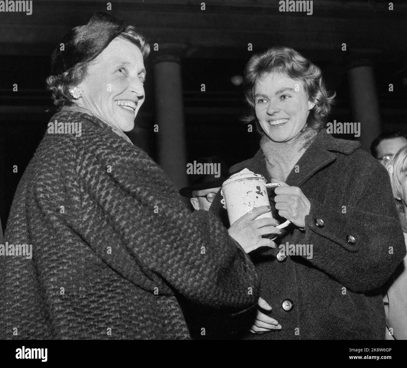 Oslo November 1956: Die Ungarn-Krise: Die Studenten in Oslo starteten eine Aktion "Give a day for Hungary", bei der sie kleine Arbeitsplätze nahmen und das Einkommen den Bedürftigen in Ungarn zukam. Die Aktion endete mit Fackelzügen und der Übergabe des Geldes auf dem Universitätsplatz. Hier erhält die Vizepräsidentin des Roten Kreuzes, Harriet Berg (TV), das Geschenk für 36.000 NOK von Brita Brandtzæg, dem Vorsitzenden der Studentenvereinigung. Foto: Aage Storløkken / Aktuell / NTB. Stockfoto