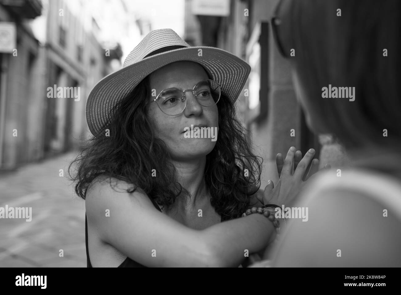 Zwei Frauen plaudern und lachen vor einer Bar in Spanien Stockfoto